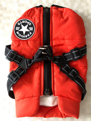 Red life jacket with black straps on a neutral background